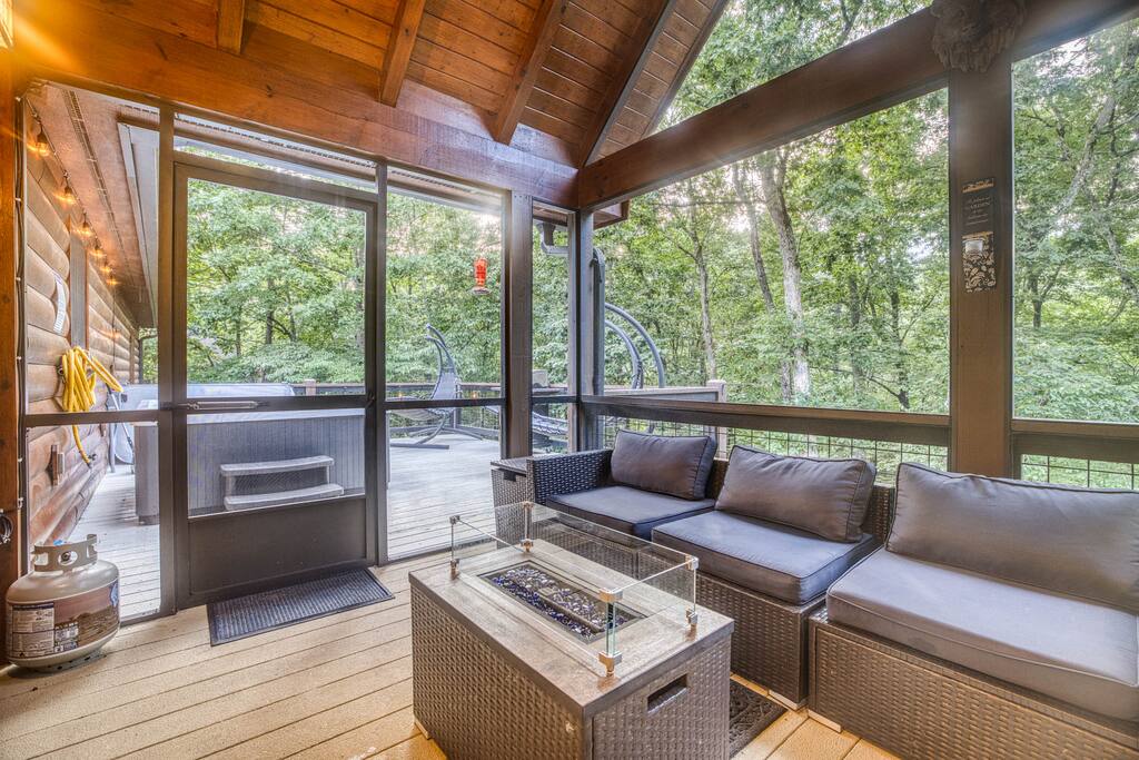 Step into an unforgettable experience with this serene screened patio, where a radiant gas fire pit becomes the heart of your evening, surrounded by luxurious wicker furniture with soft cushions—ideal for creating lasting memories with loved ones. Step into an unforgettable experience with this serene screened patio, where a radiant gas fire pit becomes the heart of your evening, surrounded by luxurious wicker furniture with soft cushions—ideal for creating lasting memories with loved ones. - Spacious Cabin, Hot Tub, Theater, Dog Run, FirePit - Ellijay