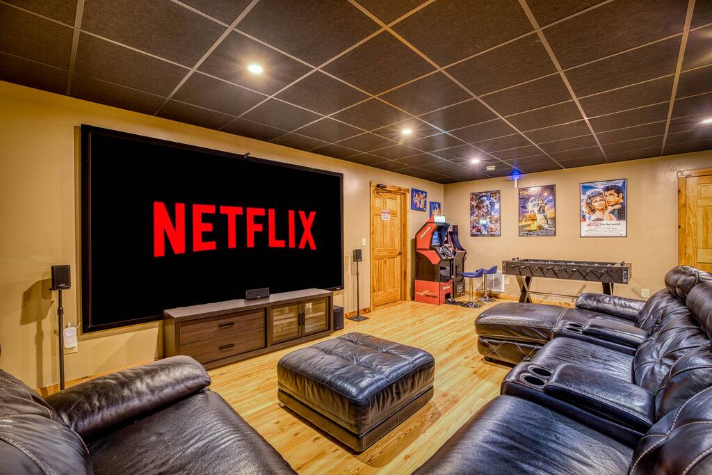 Experience the ultimate entertainment escape! This HD home theater boasts a comfy leather sectional, arcade games, air hockey, foosball, and ambient lighting control for the perfect vibe. Has direct access to a half bathroom for convenience. Experience the ultimate entertainment escape! This HD home theater boasts a comfy leather sectional, arcade games, air hockey, foosball, and ambient lighting control for the perfect vibe. Has direct access to a half bathroom for convenience. - Spacious Cabin, Hot Tub, Theater, Dog Run, FirePit - Ellijay