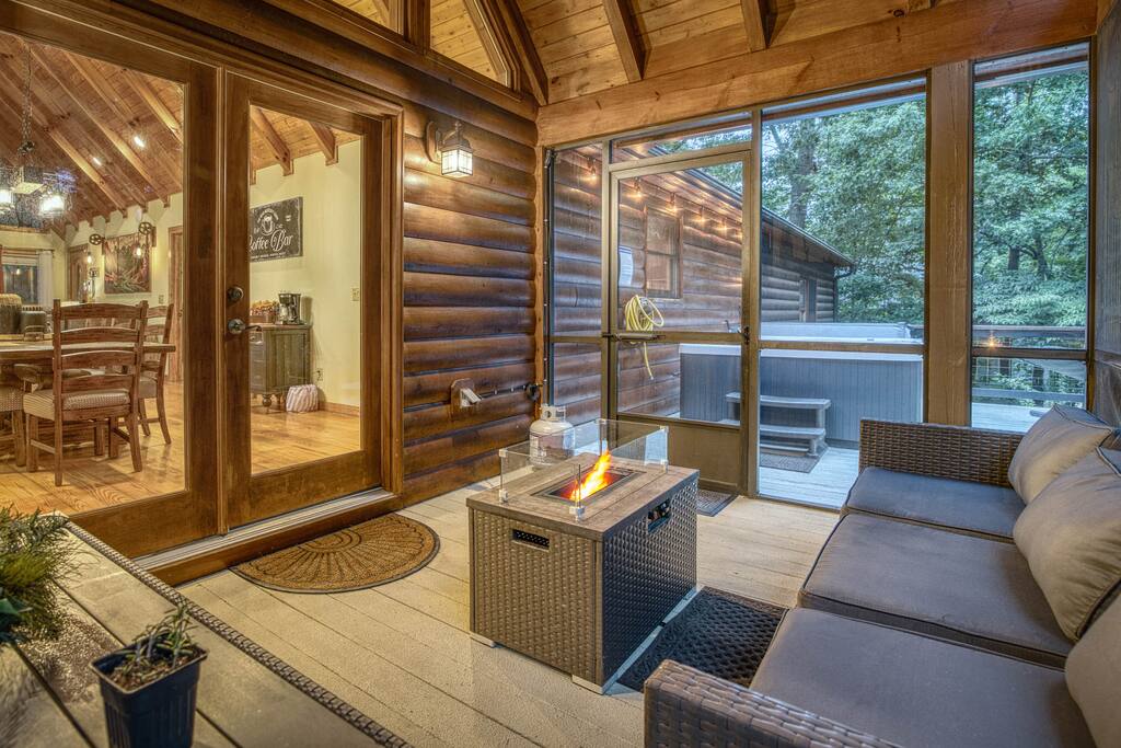 Cozy up by the gas firepit in the screened-in deck sitting area. Featuring a large patio sofa and outdoor dining table, it’s the perfect space to relax, dine, and enjoy the fresh mountain air in comfort. Cozy up by the gas firepit in the screened-in deck sitting area. Featuring a large patio sofa and outdoor dining table, it’s the perfect space to relax, dine, and enjoy the fresh mountain air in comfort. - Spacious Cabin, Hot Tub, Theater, Dog Run, FirePit - Ellijay