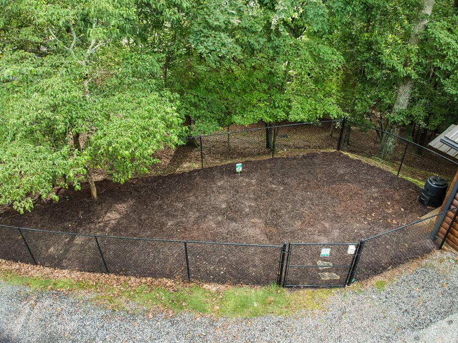 Let your fur babies romp freely in this secure fenced dog run, surrounded by lush forest views. Perfect for playtime, with a safe, shaded space. Let your fur babies romp freely in this secure fenced dog run, surrounded by lush forest views. Perfect for playtime, with a safe, shaded space. - Spacious Cabin, Hot Tub, Theater, Dog Run, FirePit - Ellijay