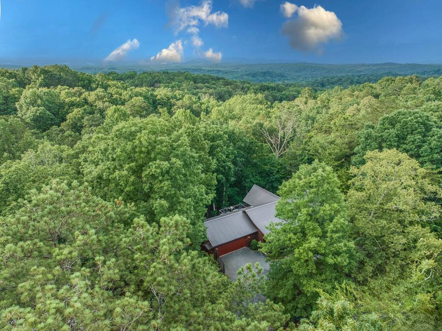 This is an aerial view from a higher elevation, revealing the cabin nestled on Eagle Mountain and the breathtaking topography of the surrounding area. A peaceful retreat surrounded by nature’s beauty awaits! Cabin is in the fore ground. This is an aerial view from a higher elevation, revealing the cabin nestled on Eagle Mountain and the breathtaking topography of the surrounding area. A peaceful retreat surrounded by nature’s beauty awaits! Cabin is in the fore ground. - Spacious Cabin, Hot Tub, Theater, Dog Run, FirePit - Ellijay