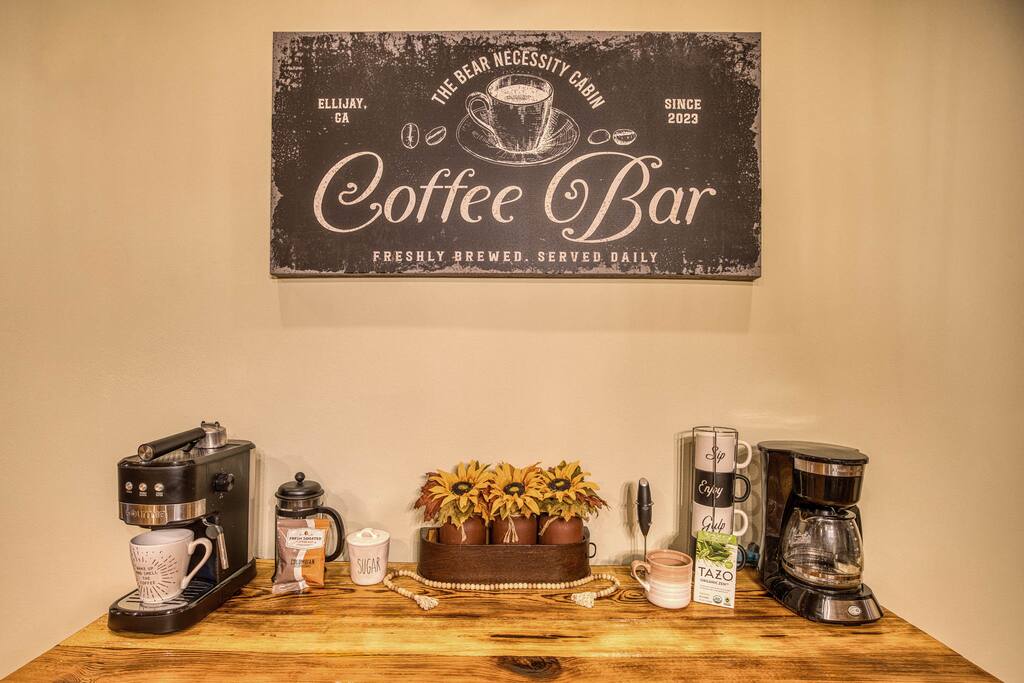 Wake up to your perfect brew! The dining area features a coffee bar with espresso and regular coffee machines, stocked with starter coffee, cream, and sugar, all set on a beautiful console cabinet. A cozy start to your mornings awaits! Wake up to your perfect brew! The dining area features a coffee bar with espresso and regular coffee machines, stocked with starter coffee, cream, and sugar, all set on a beautiful console cabinet. A cozy start to your mornings awaits! - Spacious Cabin, Hot Tub, Theater, Dog Run, FirePit - Ellijay
