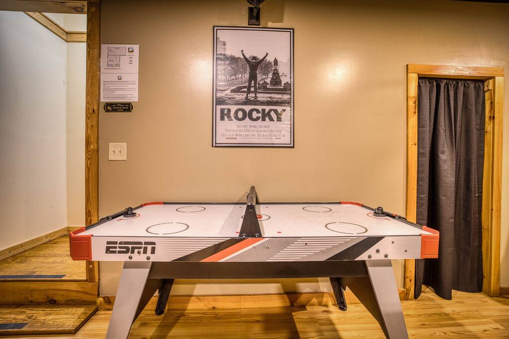 Unleash your inner champ in this game room with a sleek air hockey table! Inspired by the Rocky poster, it’s perfect for thrilling matches and fun nights. Unleash your inner champ in this game room with a sleek air hockey table! Inspired by the Rocky poster, it’s perfect for thrilling matches and fun nights. - Spacious Cabin, Hot Tub, Theater, Dog Run, FirePit - Ellijay