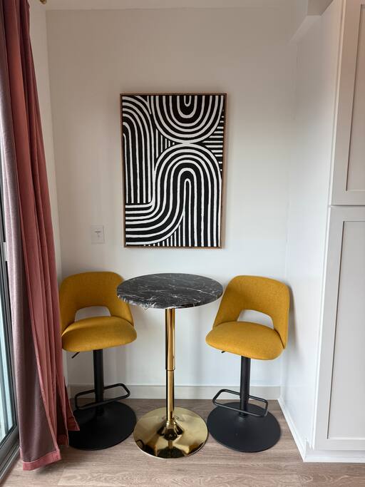Breakfast Nook | Bold Art + Bistro Seating | Main Floor
Start your day or sip a sunset cocktail in this stylish corner with mustard velvet stools, a black marble table, and modern art that pops.