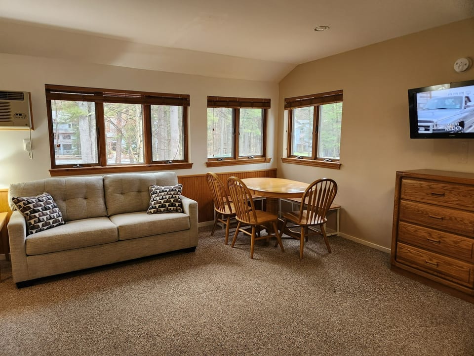 These room has multiple windows which let in great light and and lovely views. In the main room of the condo you will find a new couch to relax on. As well as an extra chair for seating along with seating for 6 around the table for dining.