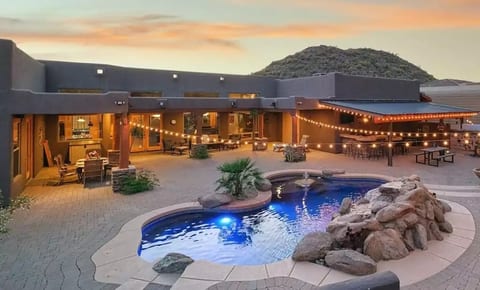This backyard oasis features a dining table, inviting patio furniture, and built in BBQ and Treager smoker. Plunge into this refreshing pool with optional heat for additional charge.