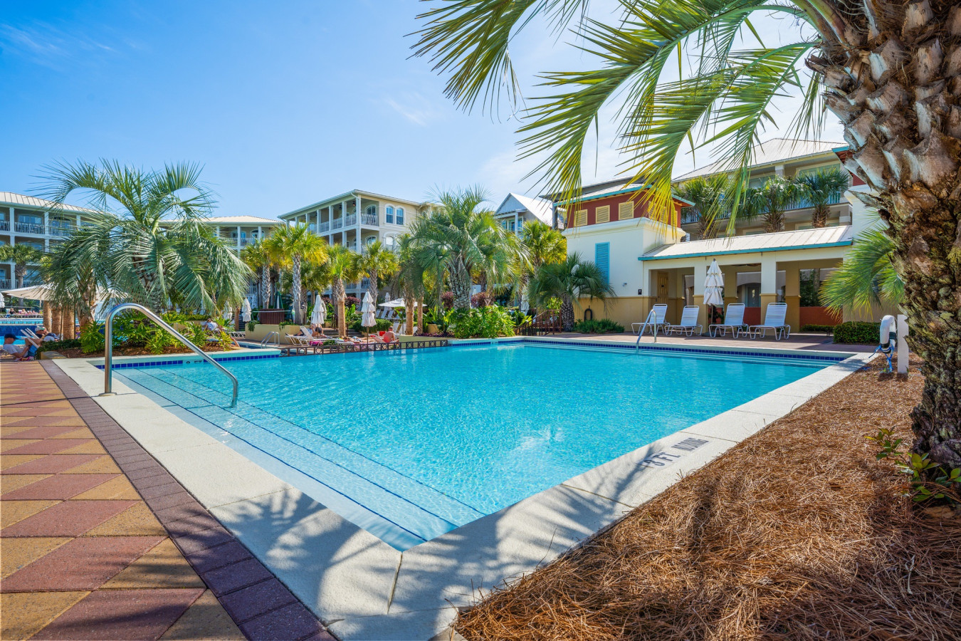 Relax at one of the quieter satellite pools in Seacrest Beach, framed by swaying palms and comfortable lounge chairs.