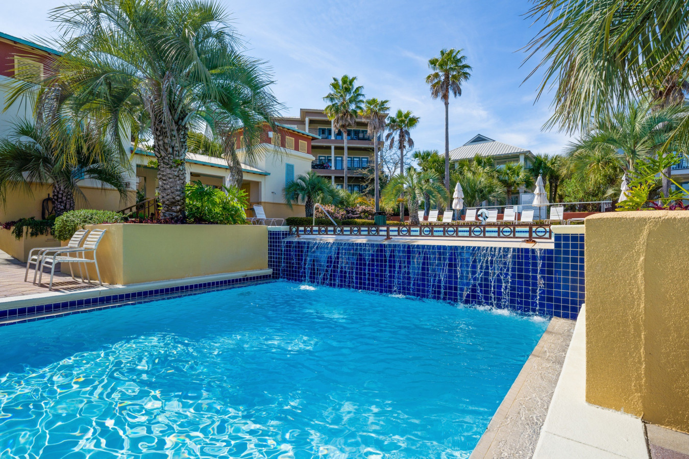 Relax by the tiered waterfall feature that adds a touch of tropical tranquility to the Seacrest Beach pool area.