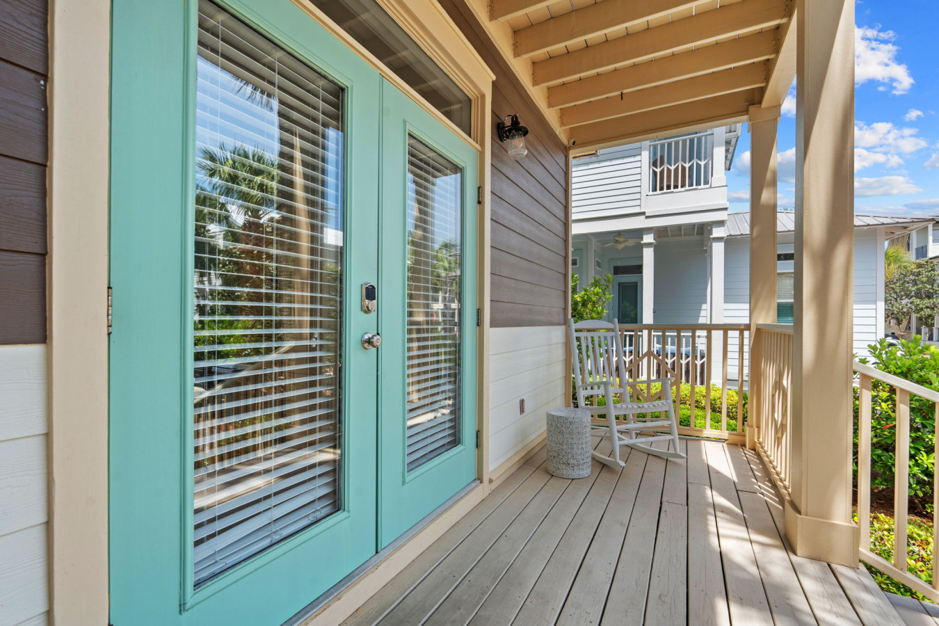 Unwind on the cozy front porch with rocking chairs and charming turquoise doors, perfect for morning coffee or evening chats.