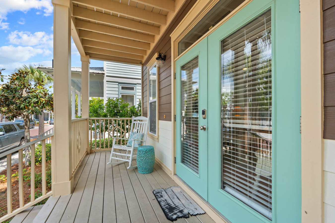 Unwind on the cozy front porch with rocking chairs and charming turquoise doors, perfect for morning coffee or evening chats.