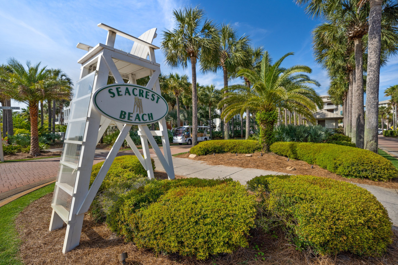 The welcoming Seacrest Beach entrance sign sets the tone for a laid-back, coastal getaway with palm-lined streets and charming scenery.