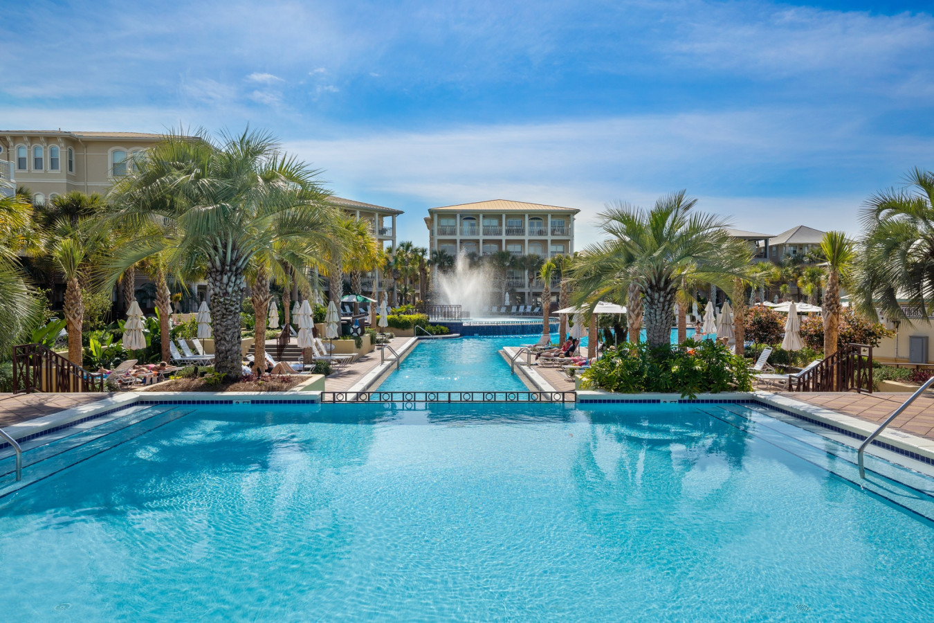 Unwind in paradise at the palm-lined lap pool with a stunning fountain view and plenty of lounge space.