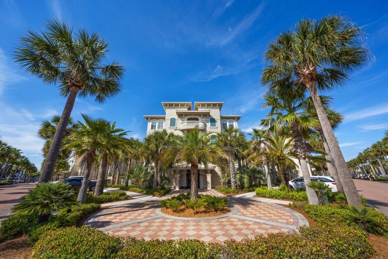 This grand palm-lined entrance showcases the elegant architecture and lush tropical landscaping of Seacrest Beach.