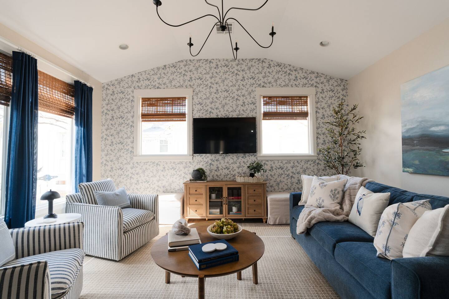 Living space with queen sleeper sofa, 2 swivel chairs, and a set of ottomans for additional seating