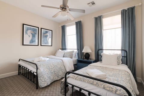 Guest bedroom with queen and twin beds. The bedroom includes a ceiling fan, portable table fan, sound machine, and room-darkening curtains. The Guest closet includes luggage rack and dresser.