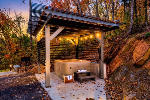 Private outdoor hot tub with pergola and adjustable slats for privacy.  Picnic style BBQ grill on the side.