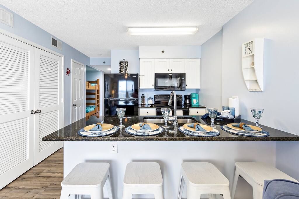 Large granite bar with eating area and fully equipped kitchen.