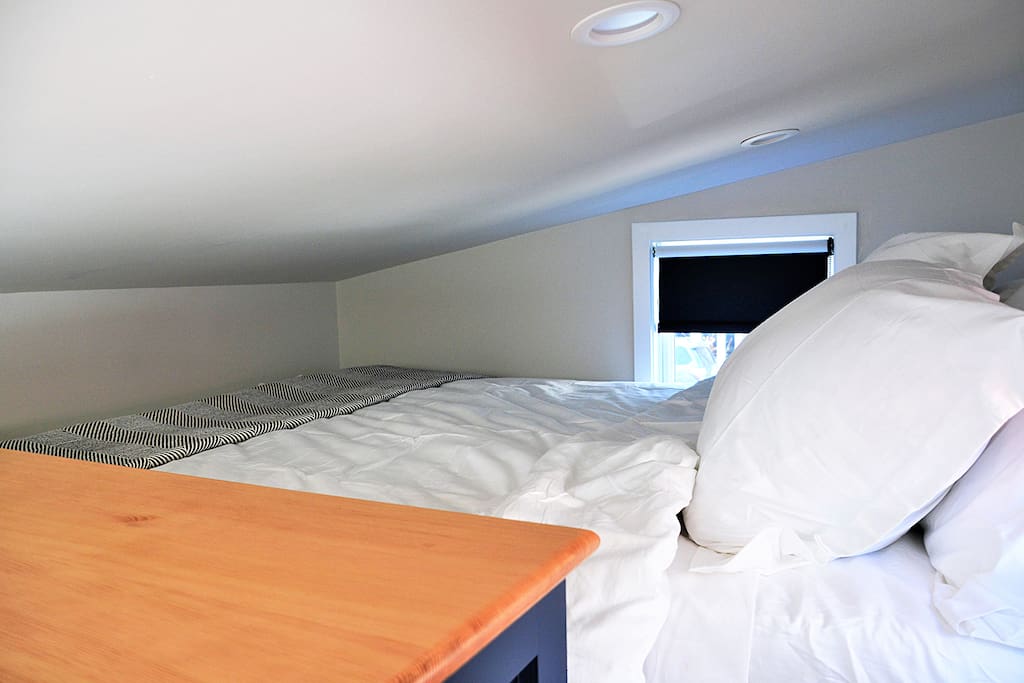 A queen size bed rests in the loft area.