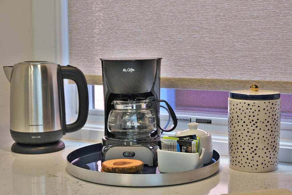 A mini-bar area sits across from the kitchen with complimentary coffee and tea.