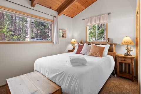 Serene bedroom w/ soft light, cozy linens & peaceful forest vibes.