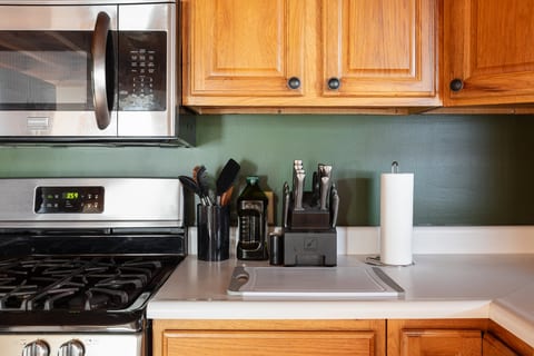 Well-equipped kitchen with gas stove, prep space, and warm wood cabinets