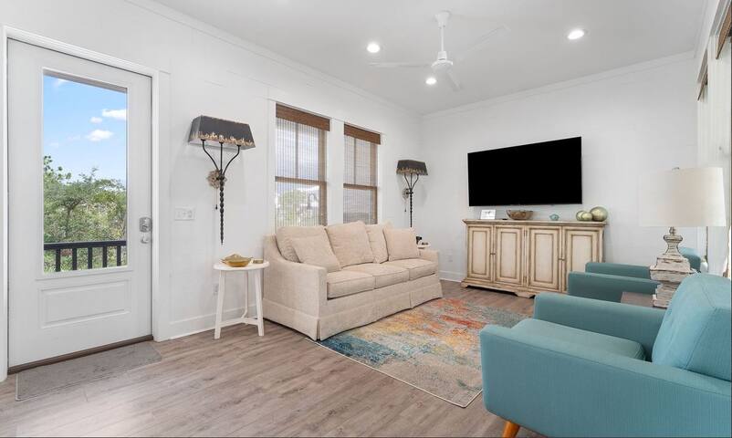 View of entrance and living area with large smart TV.