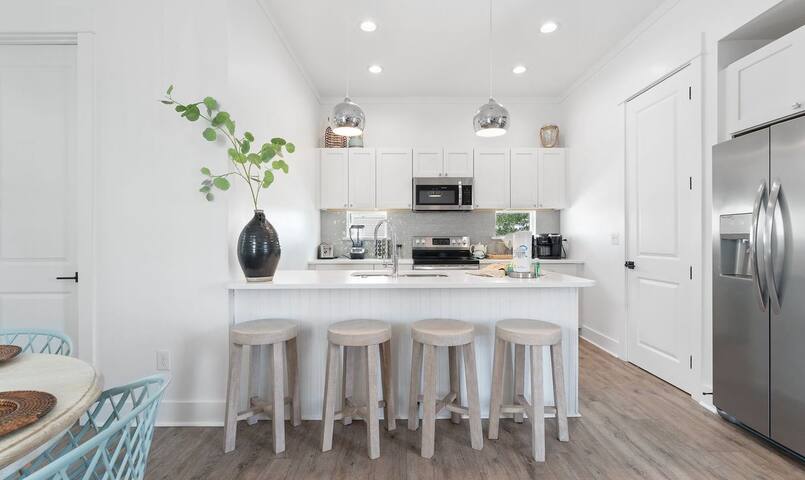 Barstools to accomodate 4 guests with well appointed kitchen in the background.