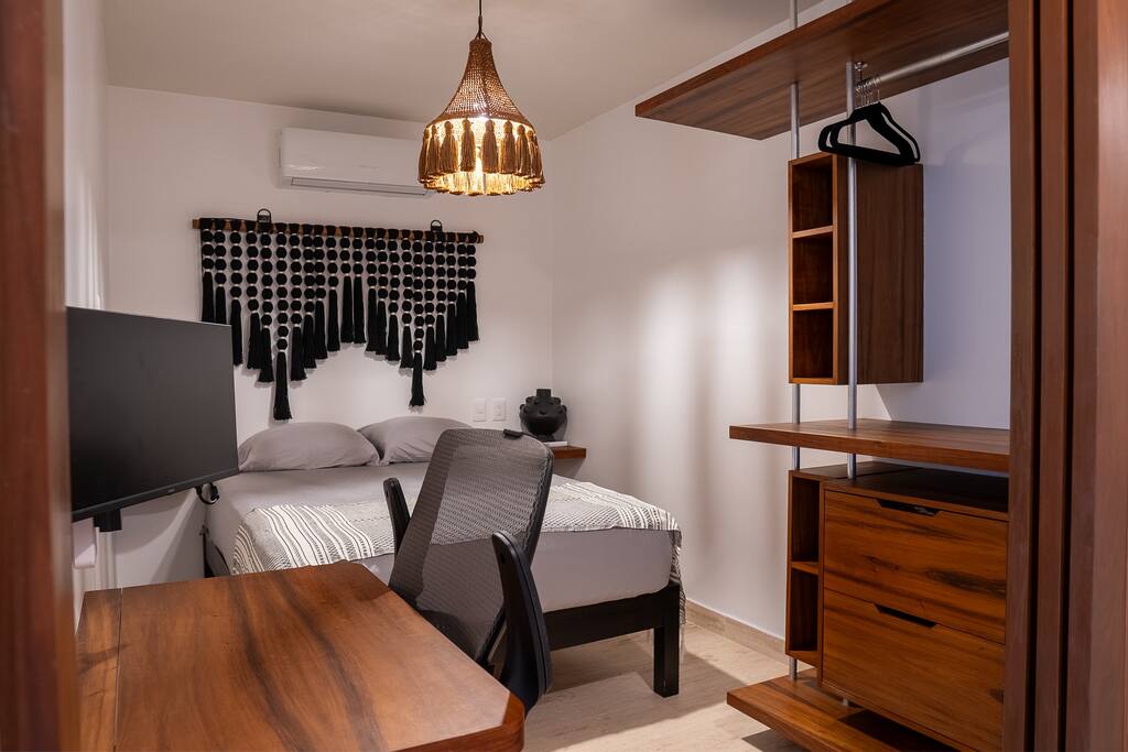 Queen-size bed and a sleek home office desk equipped with an HD monitor for productivity.