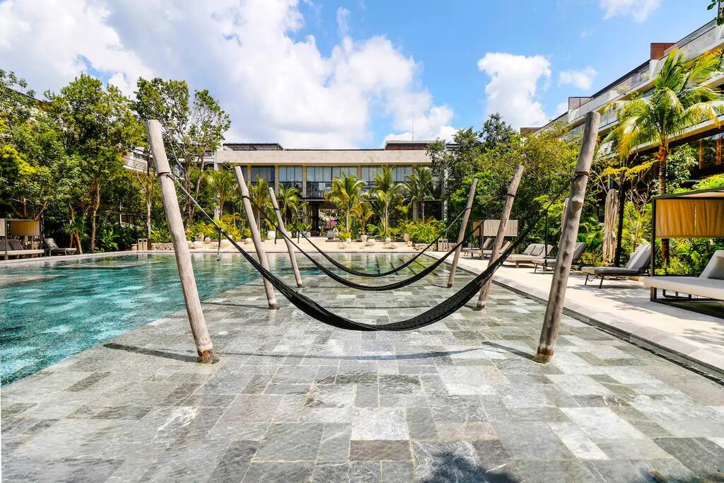 Majestic pool surrounded by inviting, cozy hammocks