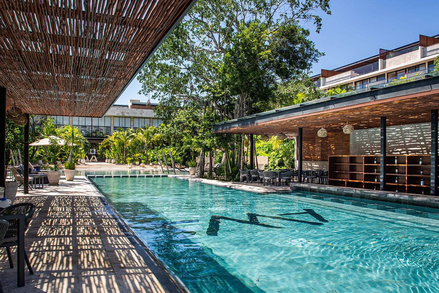 Expansive and regal pool, embodying resort luxury with a fully-serviced swim up bar.