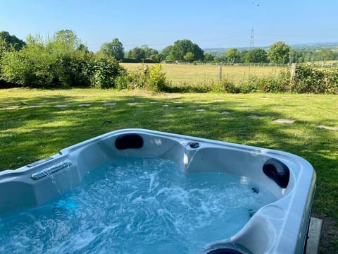 View from the hot tub across the garden to the fields.
Sheep and horses often graze in the fields beyond — no wellies required to watch them, just lean back, enjoy the powerful massage jets and drink in the glorious view.