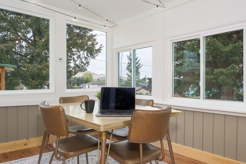 The sunroom is a great WFH location, with lush pines surrounding the large windows.