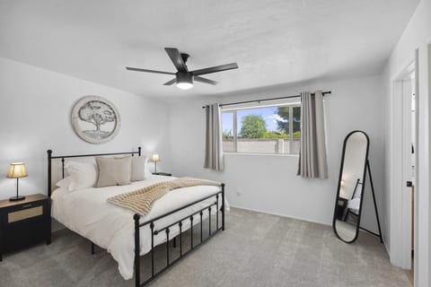 Bright bedroom w/ ceiling fan, plush bedding & a calm setup for restful nights.
