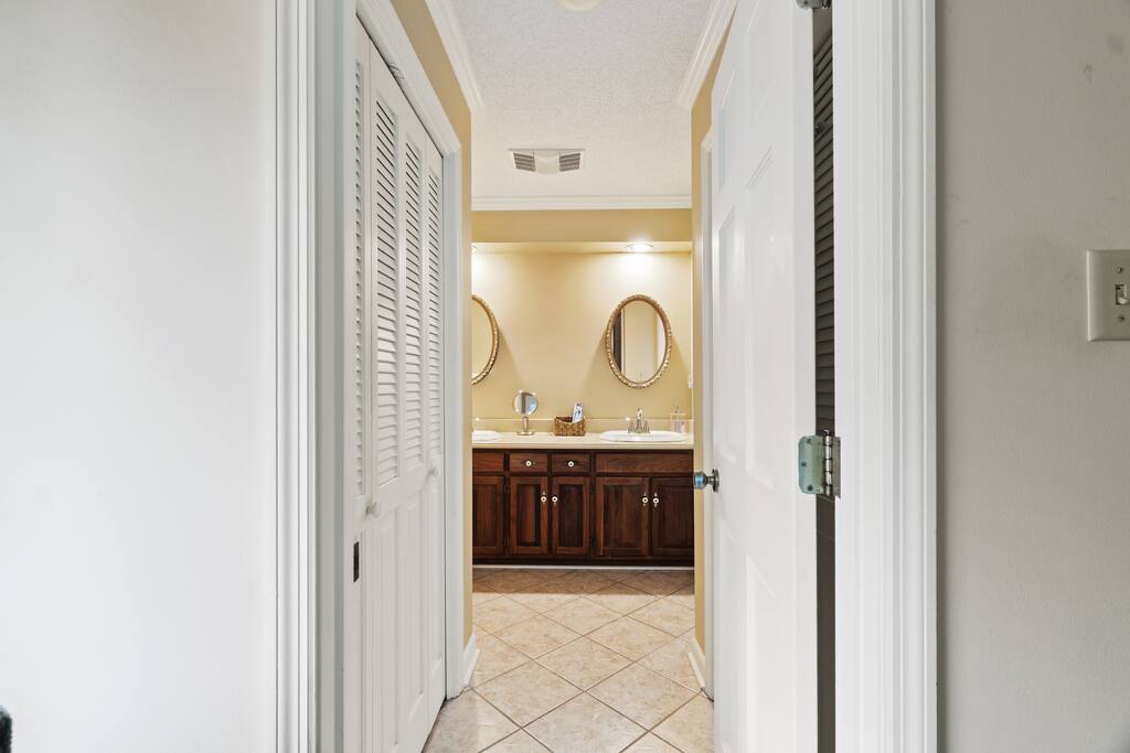 This is the primary en-suite bathroom, connected to the main floor bedroom, featuring a separate dual vanity area for added space and convenience