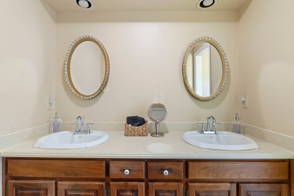 This is the primary en-suite bathroom, connected to the main floor bedroom, featuring a separate dual vanity area for added space and convenience