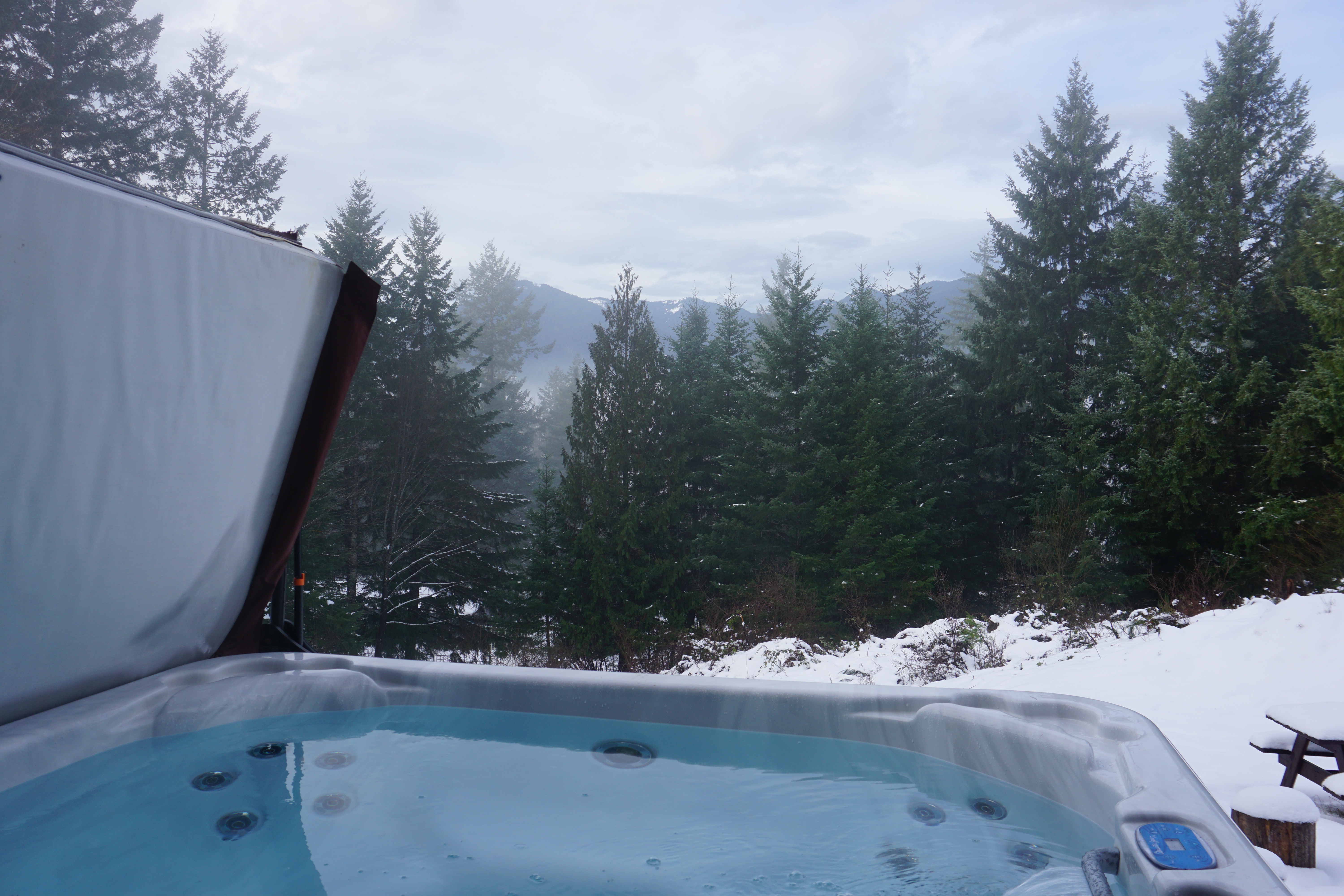 Indulge in ultimate relaxation as you soak in our luxurious hot tub, surrounded by panoramic mountain vistas by day and a canopy of twinkling stars by night, creating an unforgettable experience 