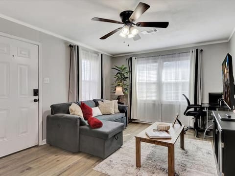 Cozy living space with Smart TV, sofa bed, blackout curtains, and relaxing decor