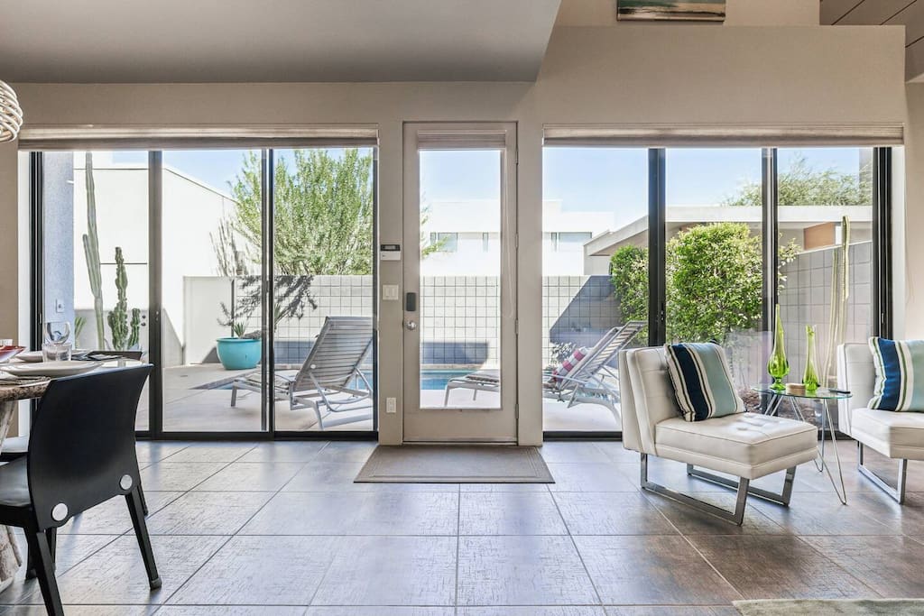 Step into style! This artistic modern living room seamlessly flows to the courtyard and pool, creating an inviting space for relaxation and fun. ️ Enjoy outdoor dining surrounded by lush greenery. Perfect for creating unforgettable memories!