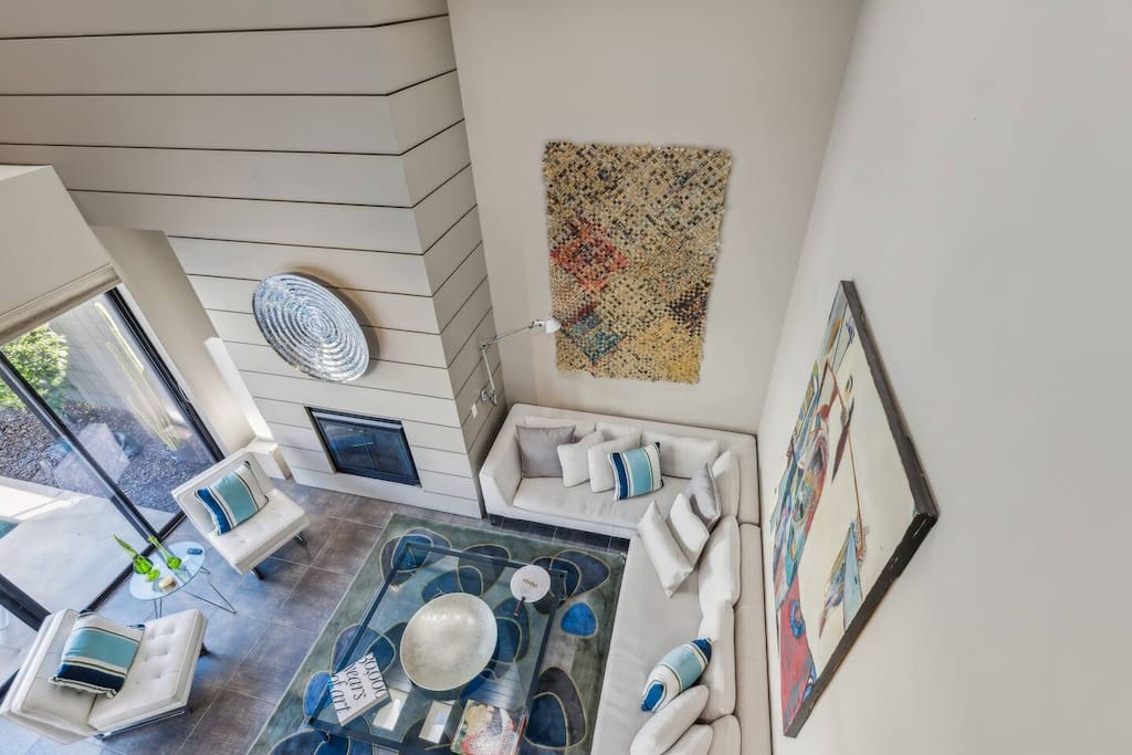 From the loft, enjoy views of the living room and the inviting pool courtyard below.