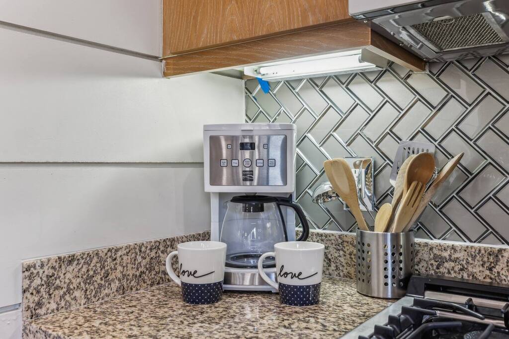 Welcome to our charming kitchen, featuring modern appliances and beautiful countertops! Start your day with a freshly brewed coffee from our top-of-the-line coffee machine, and enjoy meals in the cozy dining nook. Perfect for culinary adventures!
