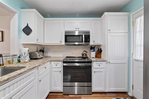 Fully stocked kitchen with microwave, dishwasher, electric range, refrigerator and washer and dryer.