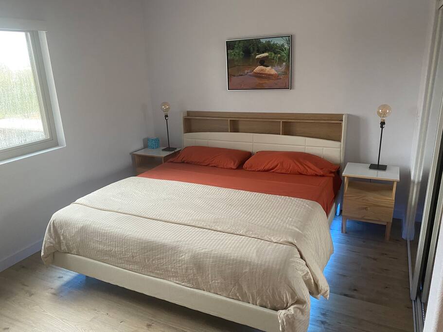 King bed in master bedroom with hard wood floors.