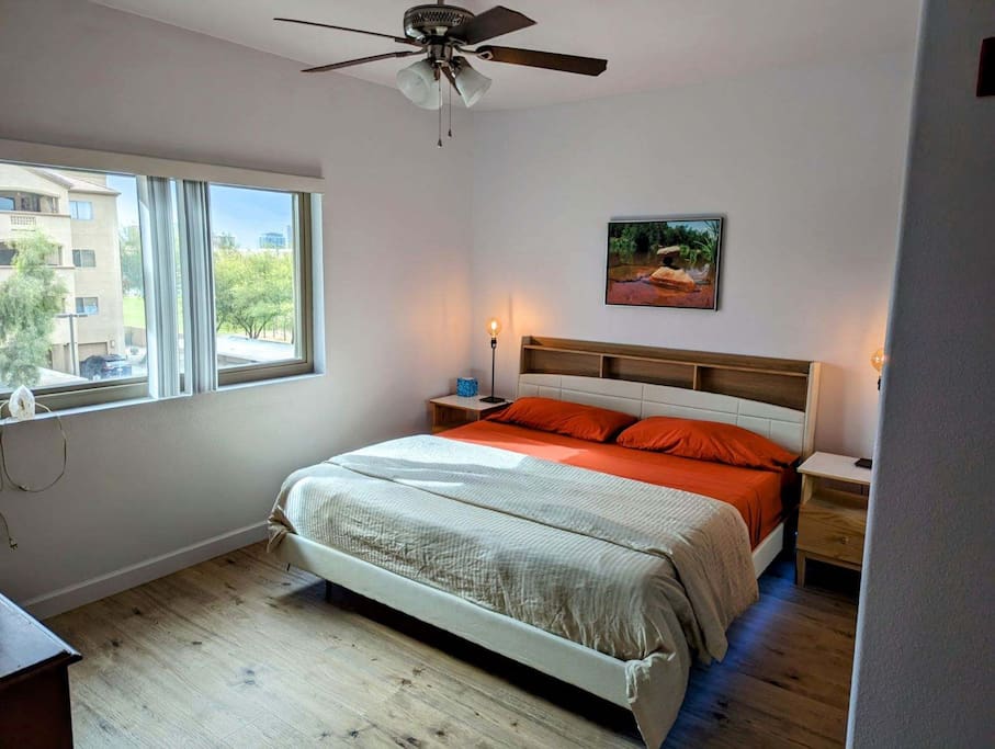 King bed in master bedroom with hard wood floors.
