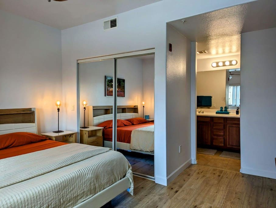 King bed in master bedroom with hardwood floors.