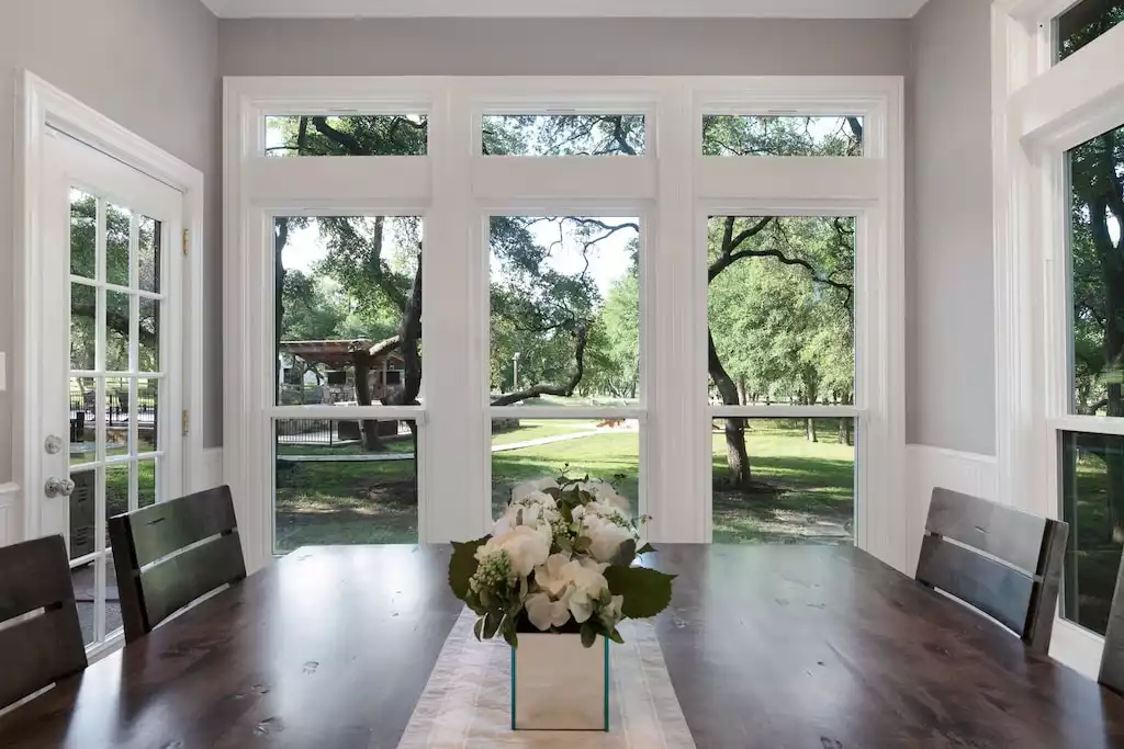 Table with 4 chairs and 2 benches with panoramic views of the surrounding trees. - Main House at Whispering Oaks Estate - Dripping Springs