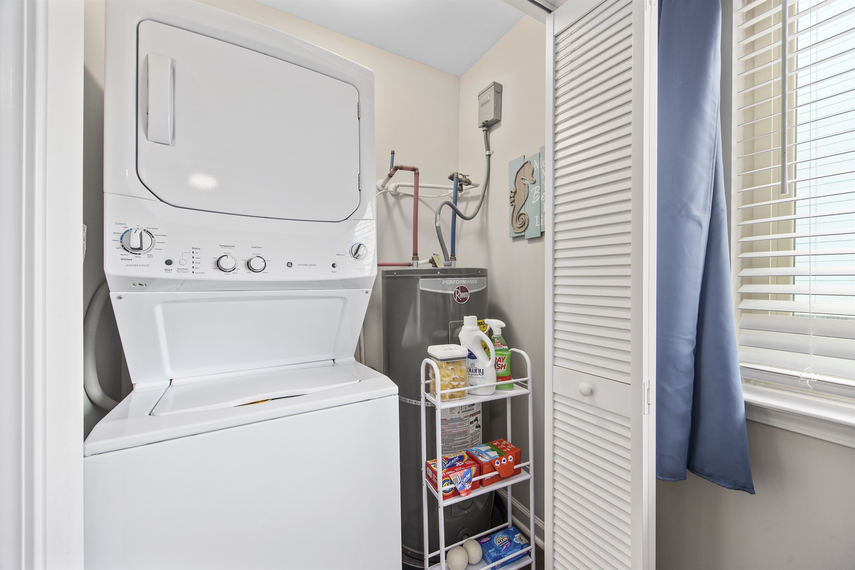 Stacked washer/dryer in mermaid room - complete with laundry supplies!