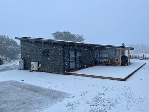Modern house with covered deck in a peaceful snowy setting