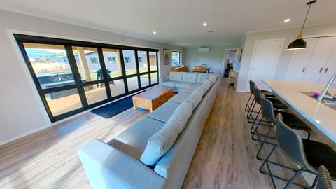 Bright open-plan lounge with large sectional and indoor-outdoor flow