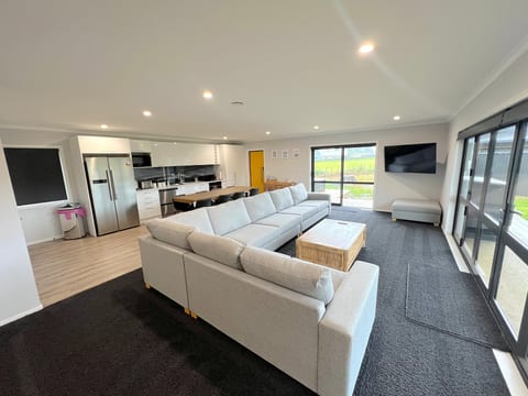 Spacious open-plan lounge with modern kitchen and sun-filled outdoor access