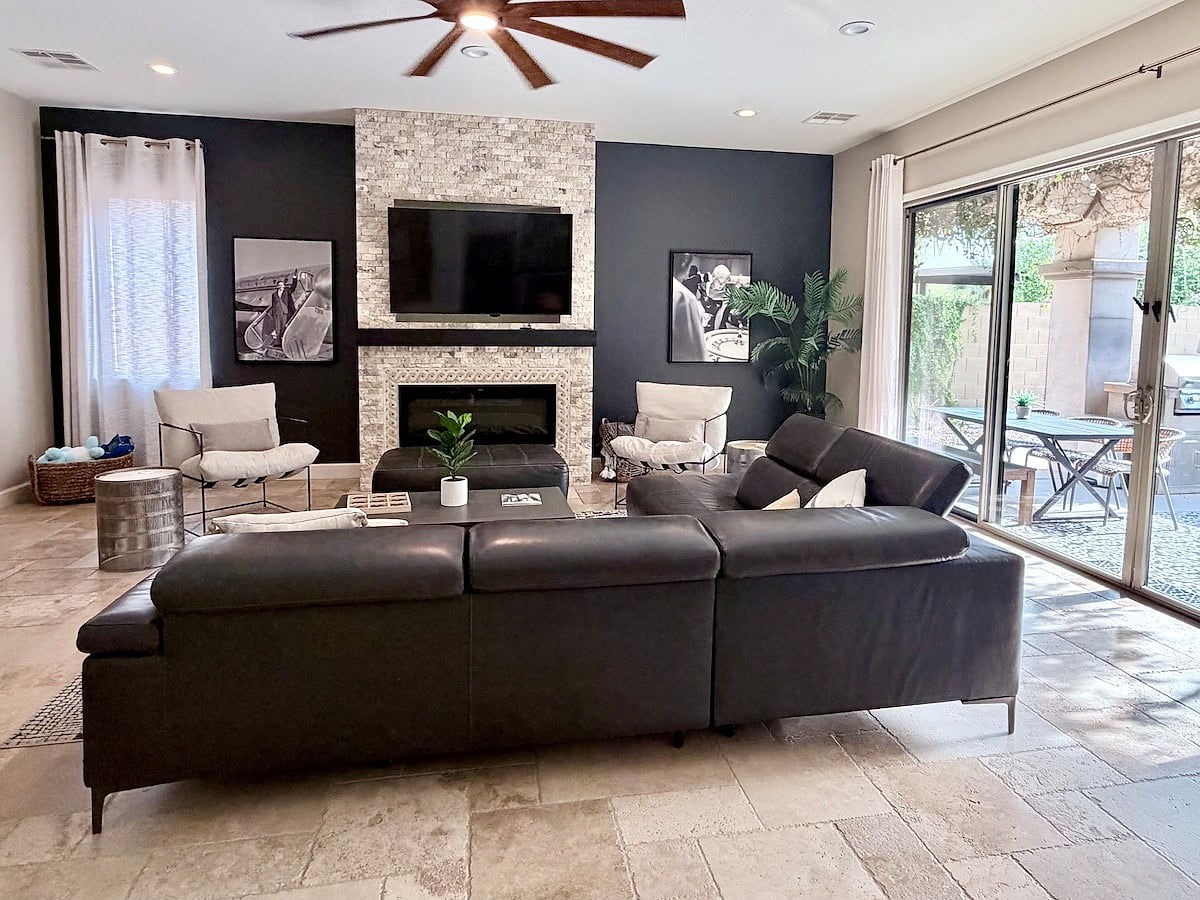 Open concept living room with fireplace,  TV & patio access.